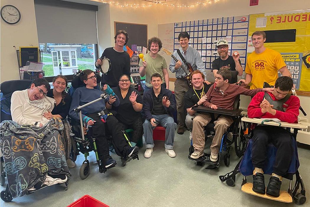 A classroom of teachers and students, some holding musical instruments